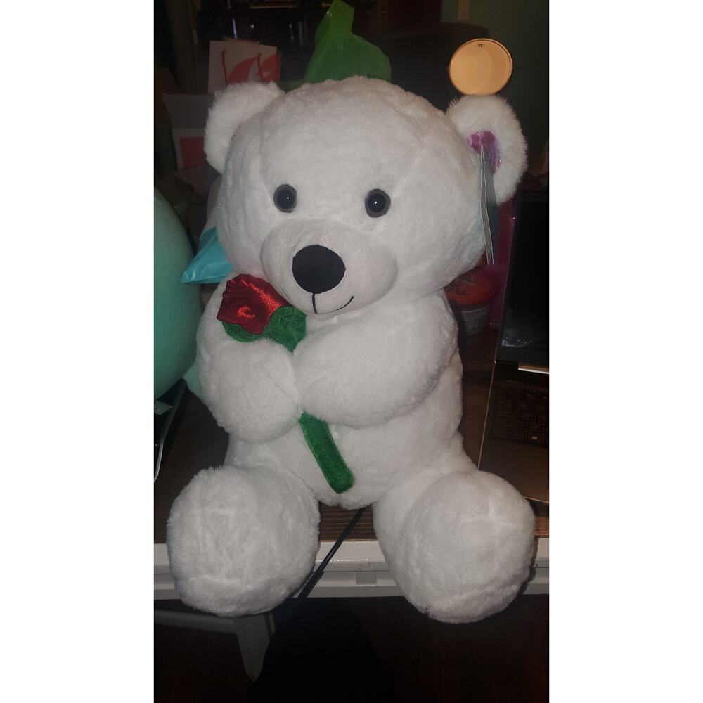 Large white teddy bear with rose